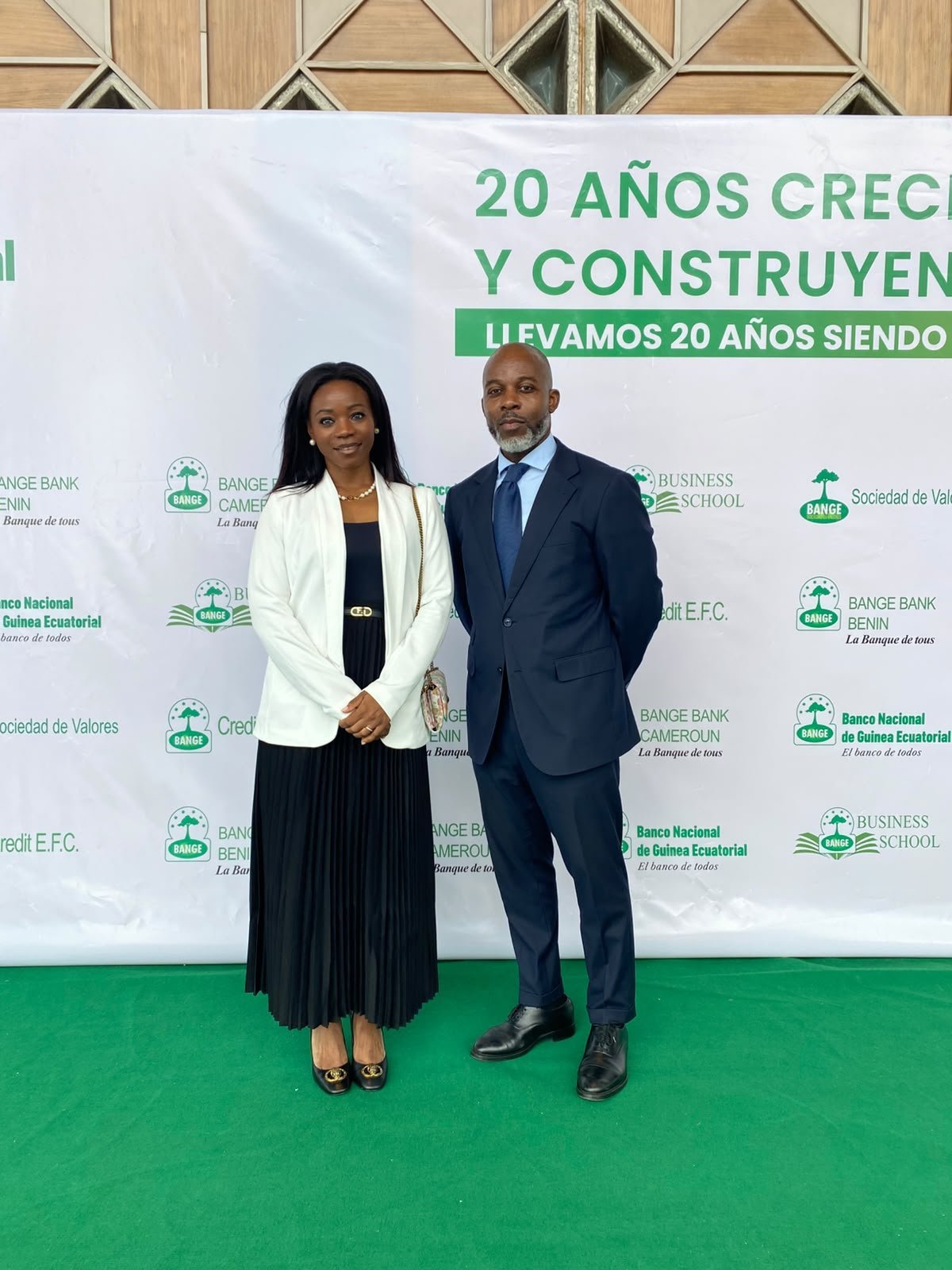 Deux participants posent pour une photographie complète devant le fond pour le 20e anniversaire de BANGE.